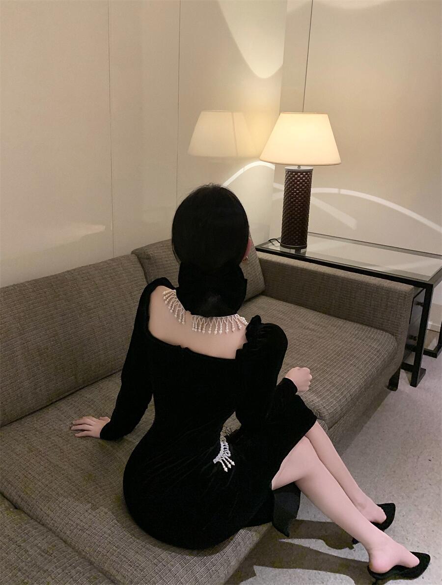 Vestido negro de terciopelo con mangas abullonadas, cuello cuadrado y pechera de perlas