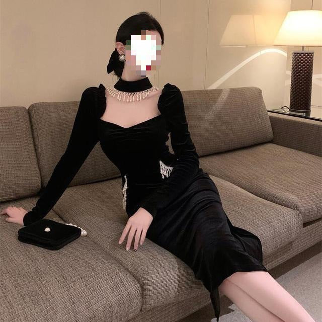 Vestido negro de terciopelo con mangas abullonadas, cuello cuadrado y pechera de perlas