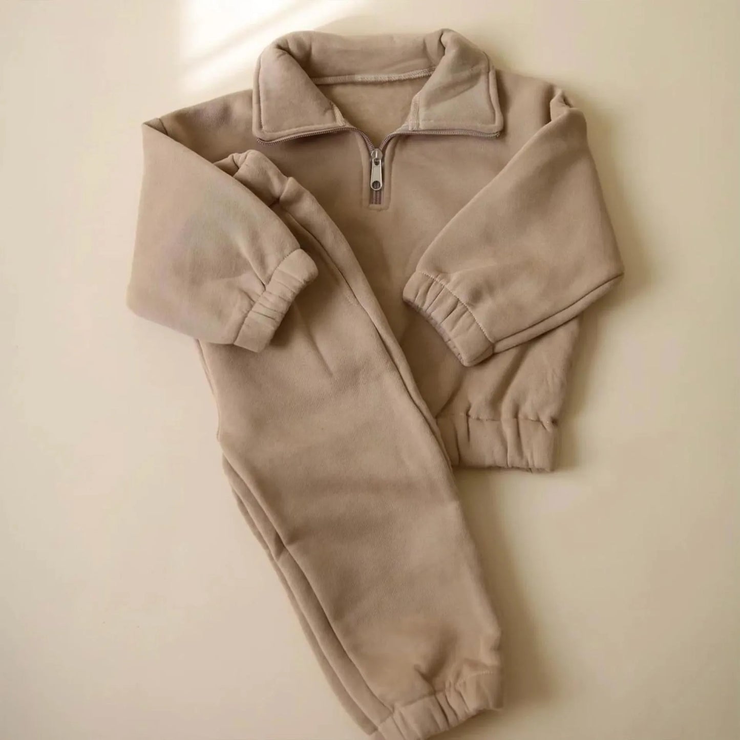 Traje informal de forro polar con pantalones con banda en el tobillo y media cremallera con cuello alto