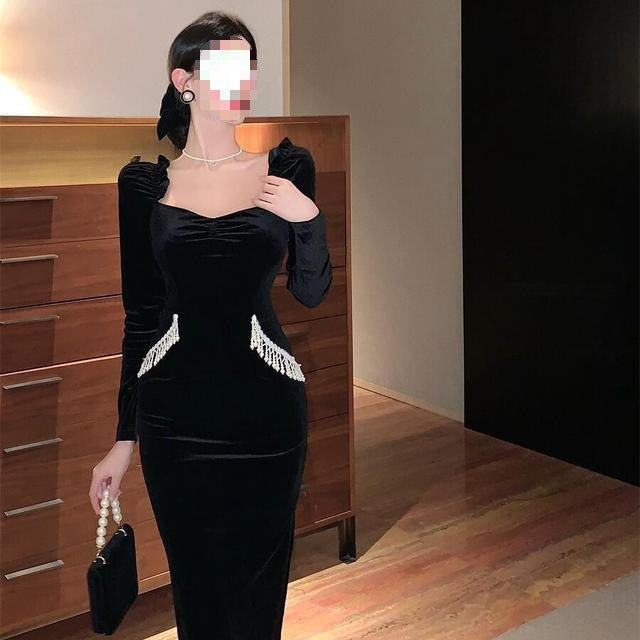 Vestido negro de terciopelo con mangas abullonadas, cuello cuadrado y pechera de perlas